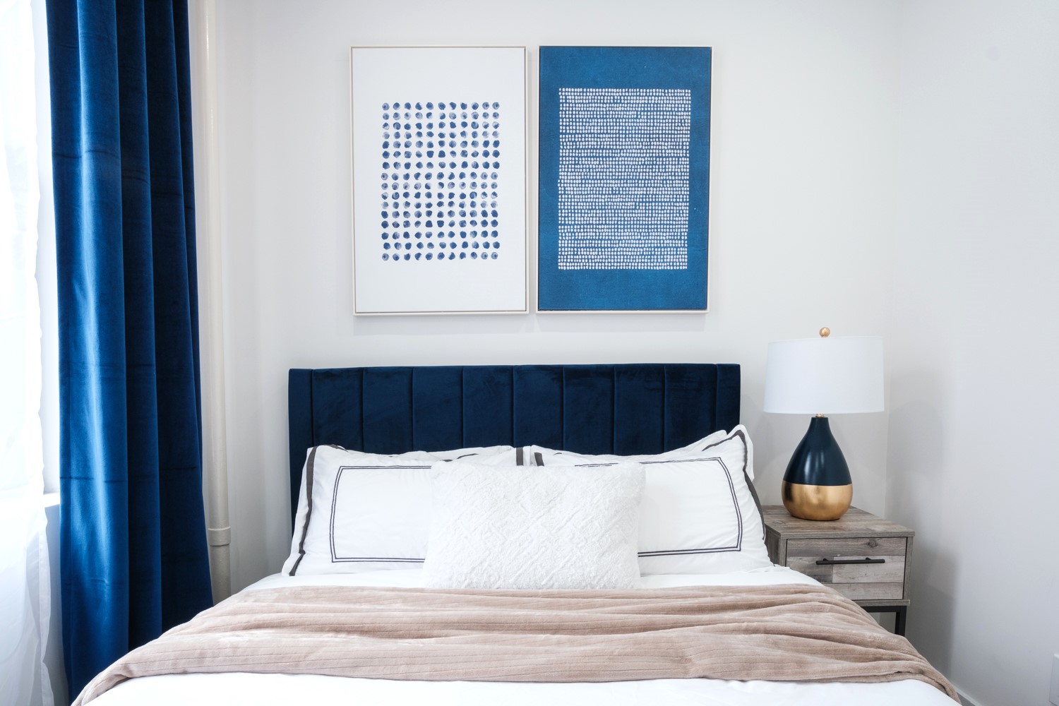 Bedroom with navy velvet curtains, navy headboard and two blue dot prints